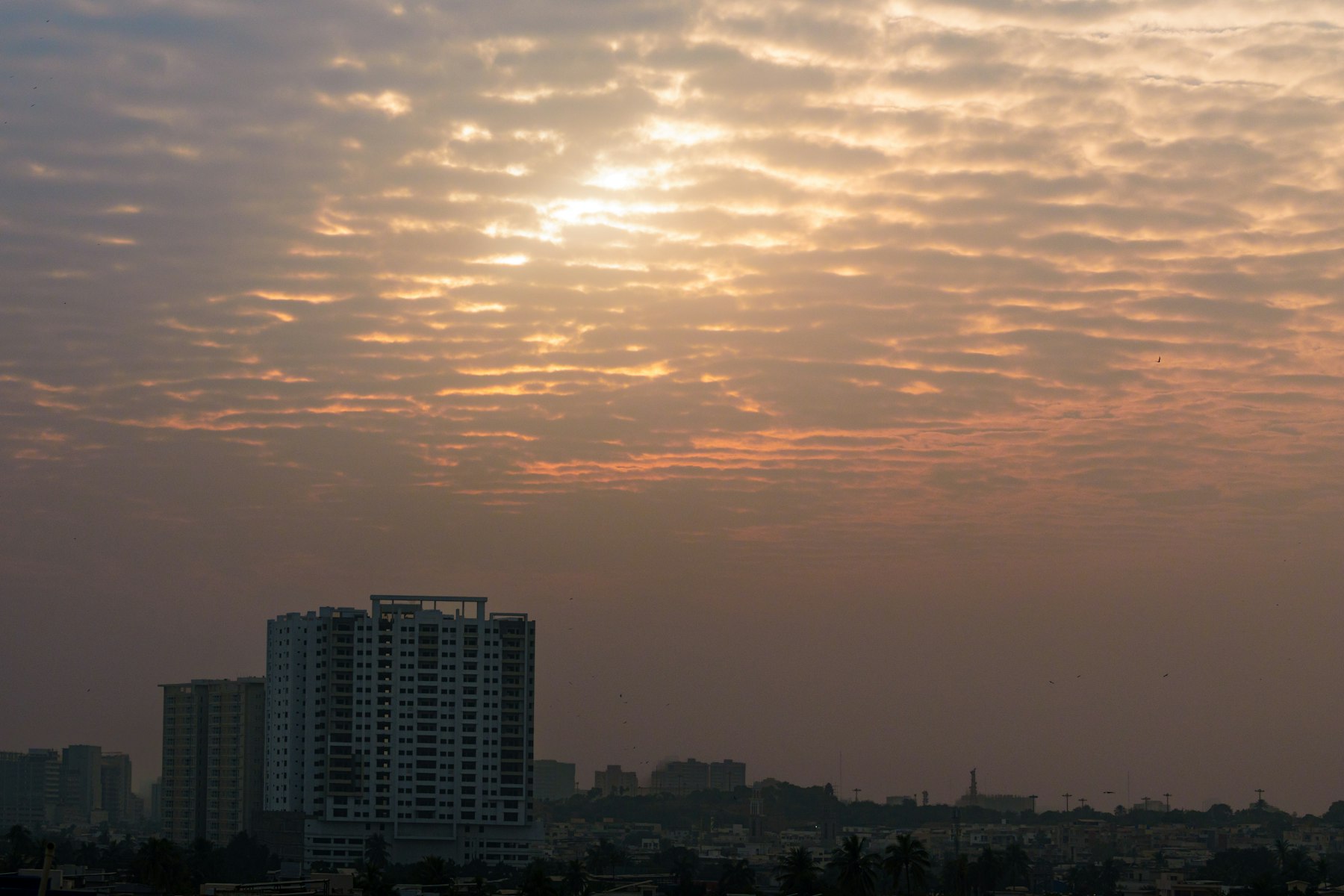 Sunrise over a city skyline with clouds