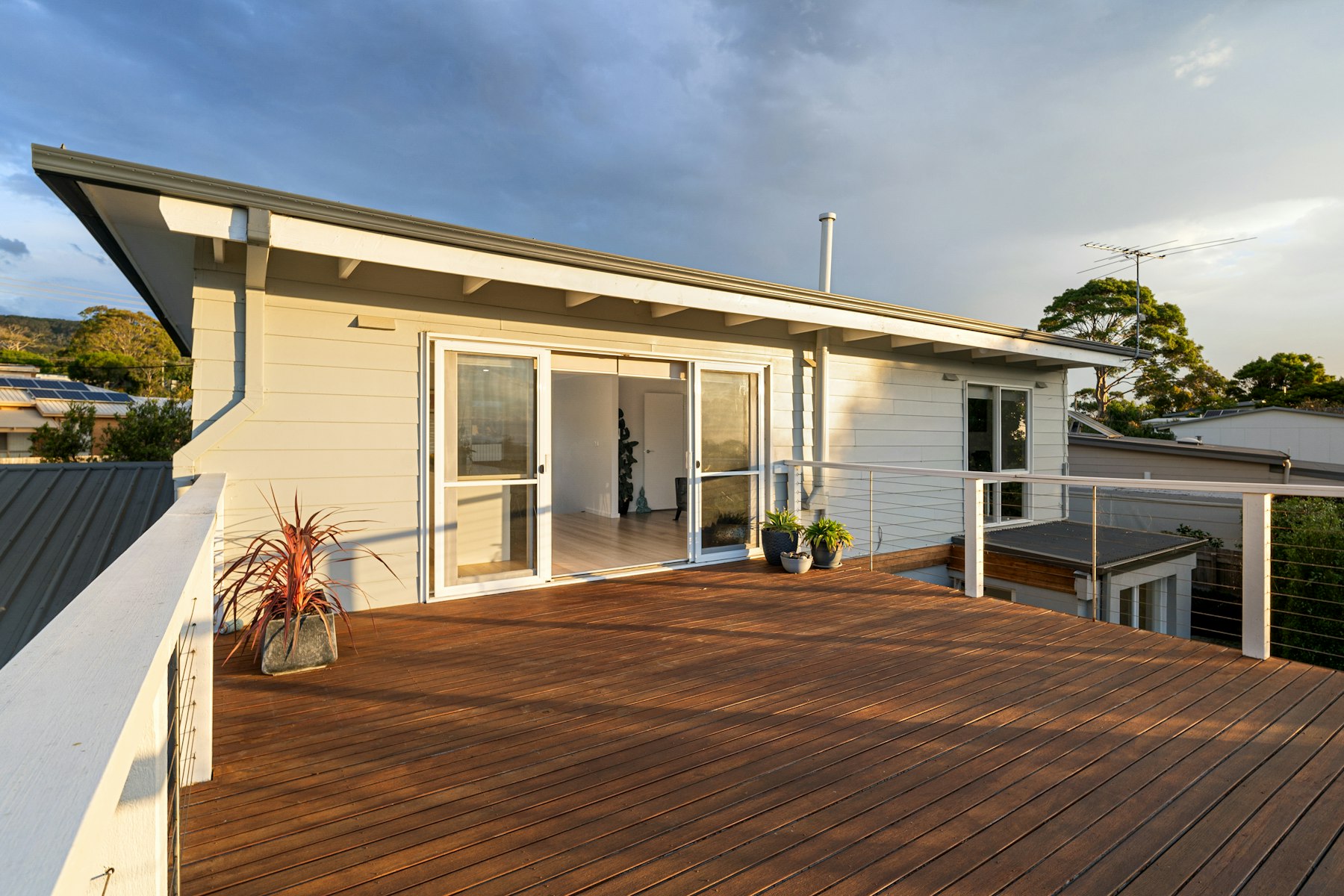 Wooden deck with a white house in the background