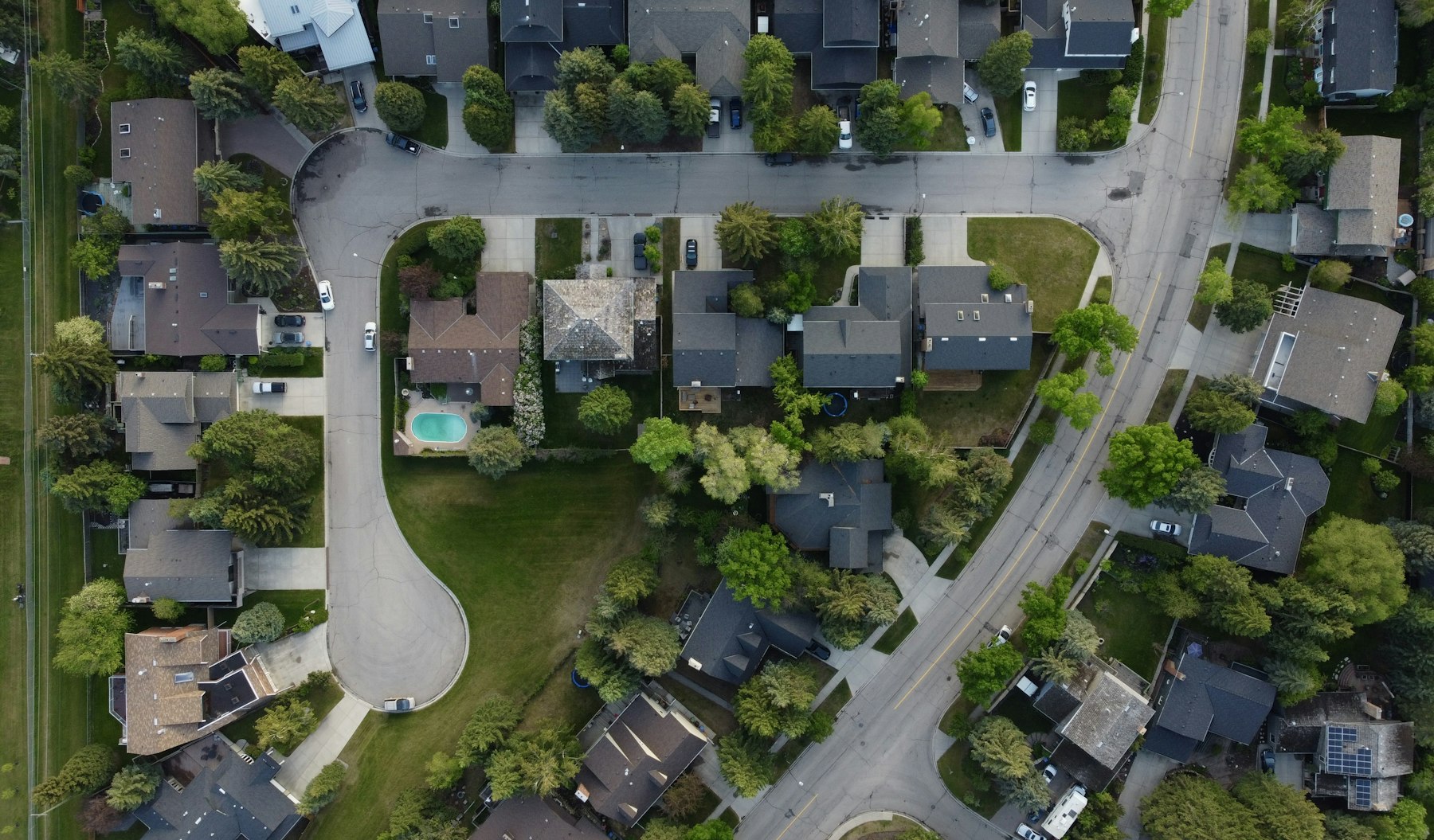 Aerial view of an upscale suburban neighborhood with multiple homes and curving streets