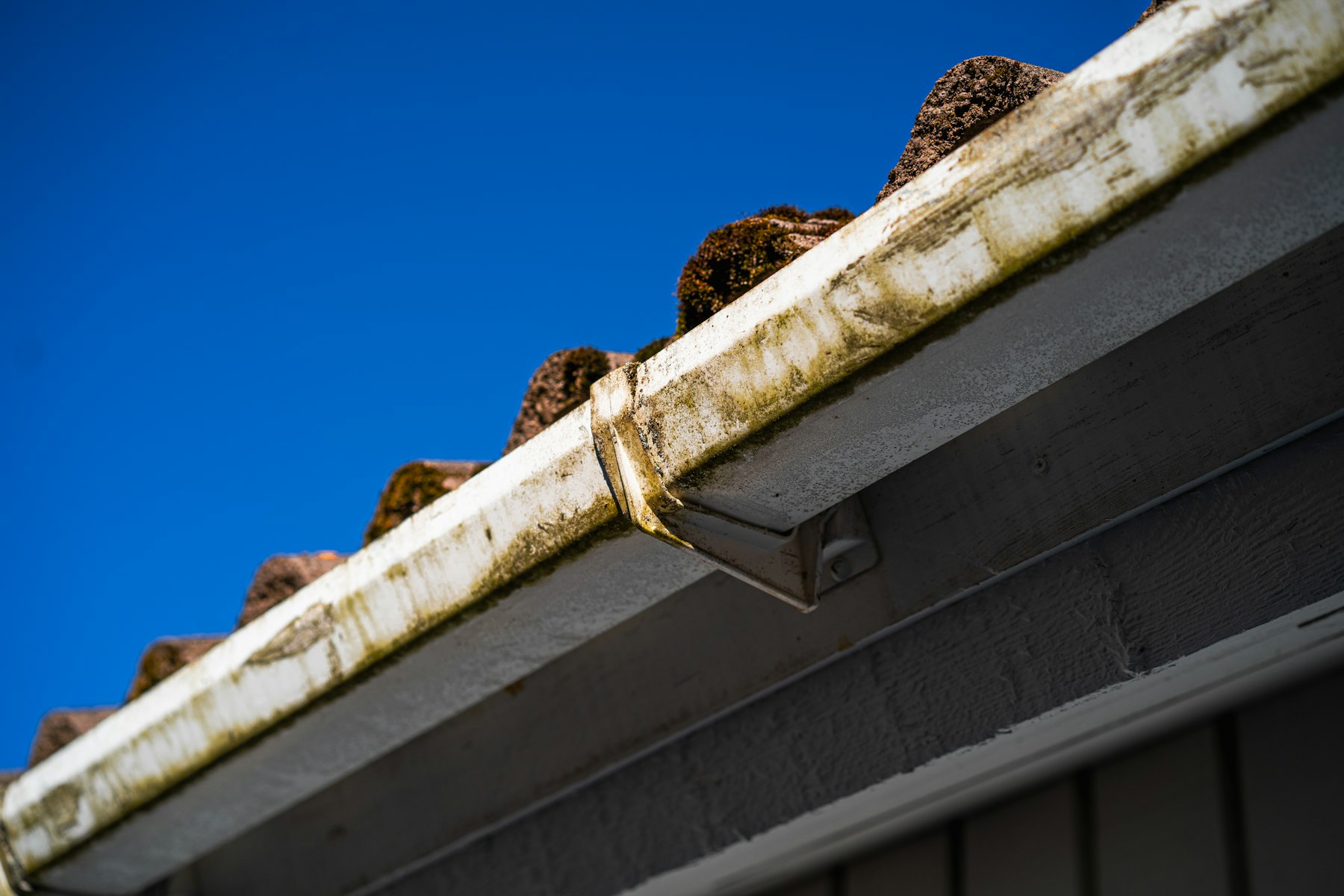 Rain gutters and roof eaves against a blue sky