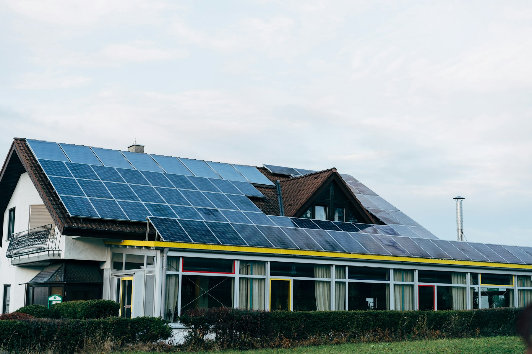 House with solar panels installed on the roof under a blue sky