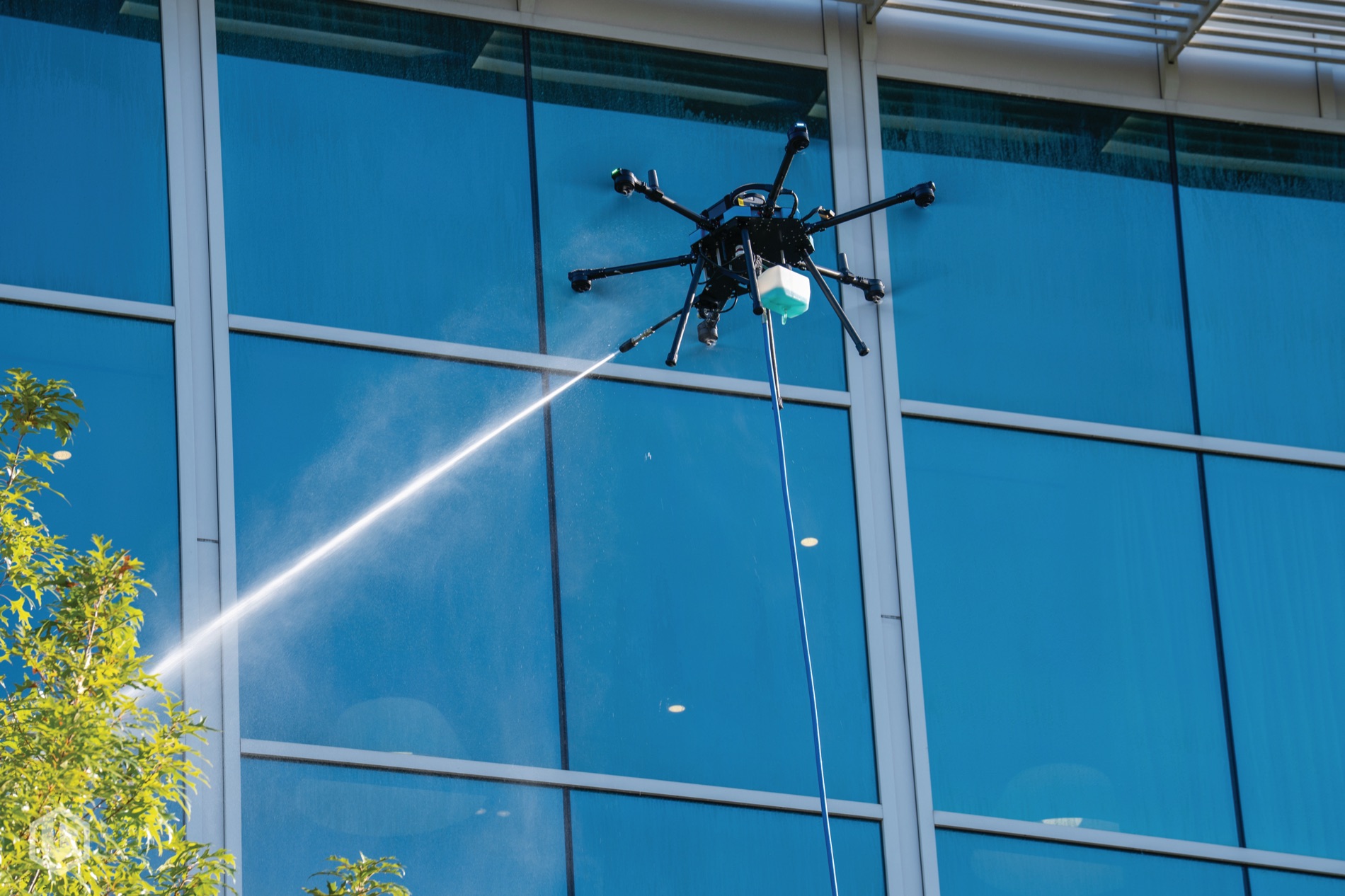 A cleaning drone washing exterior glass on a curtain wall
